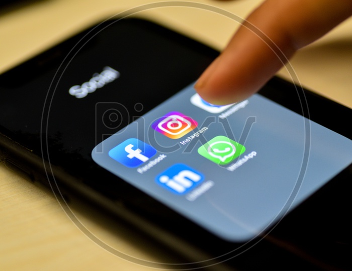 Social Network Apps On a Smartphone Screen Closeup With Man Finger On Instagram