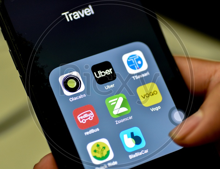 Online Travel  Apps Installed Icons on Smartphone Screen With  Man Finger Opening App