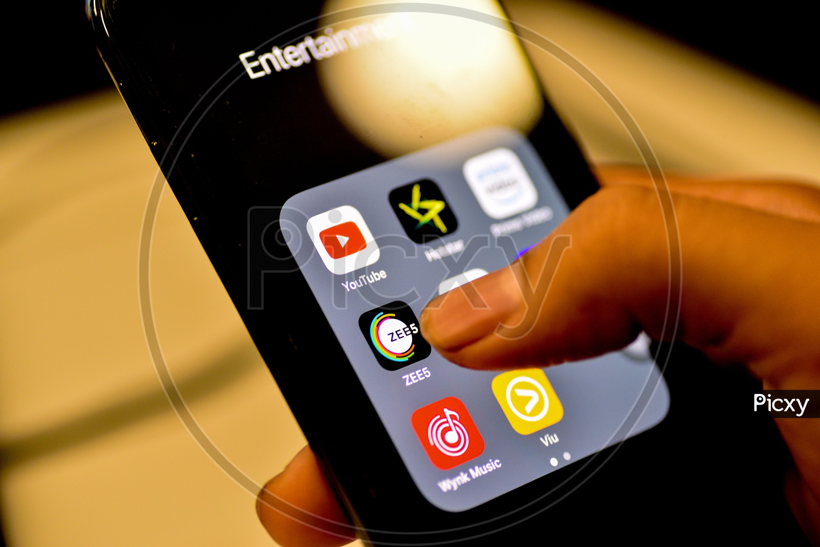 Entertainment Online Streaming Apps Installed Icons  On a Smartphone Screen Closeup With Man Finger Opening Zee5  App