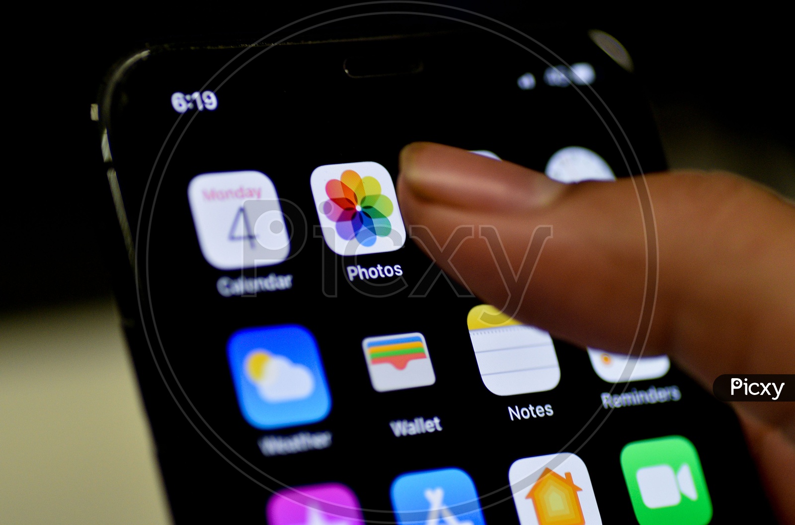 Man Finger Opening Photos App On Apple Iphone Screen Closeup