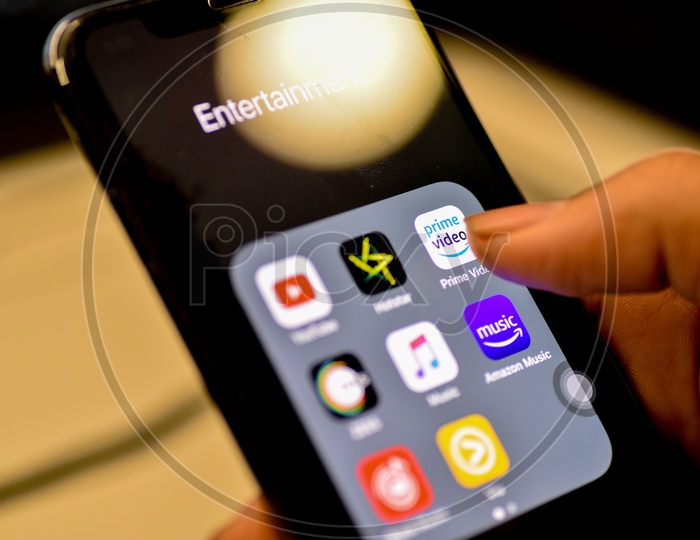 Entertainment Online Streaming Apps Installed Icons  On a Smartphone Screen Closeup With Man Finger Opening Amazon Prime  App