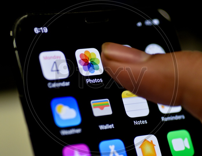 Man Finger Opening Photos App On Apple Iphone Screen Closeup