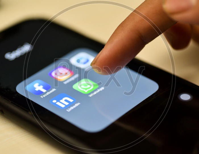 Social Network Apps On a Smartphone Screen Closeup With Man Finger On Whatsapp