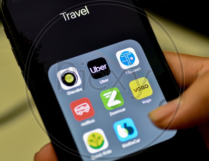 Online Travel  Apps Installed Icons on Smartphone Screen With  Man Finger Opening App