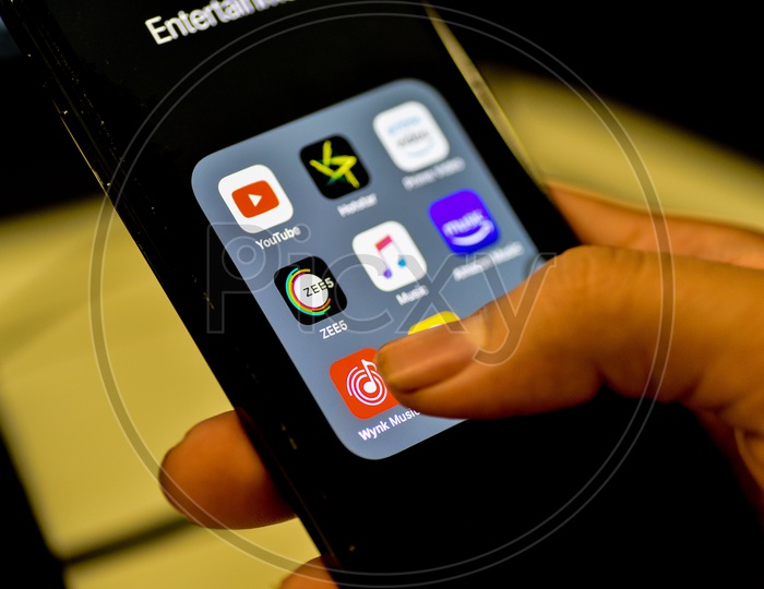 Entertainment Online Music Streaming Apps Installed Icons  On a Smartphone Screen Closeup With Man Finger Opening Wink music  App