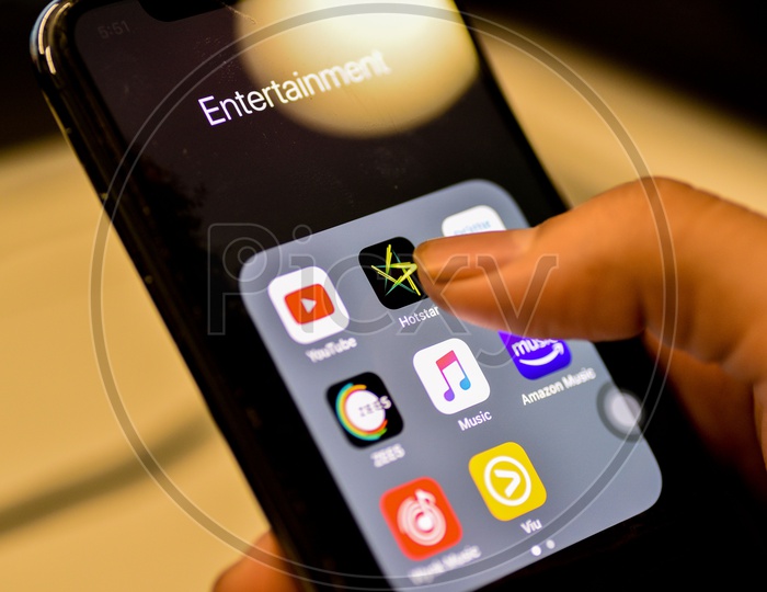 Entertainment Online Streaming Apps Installed Icons  On a Smartphone Screen Closeup With Man Finger Opening Hotstar  App