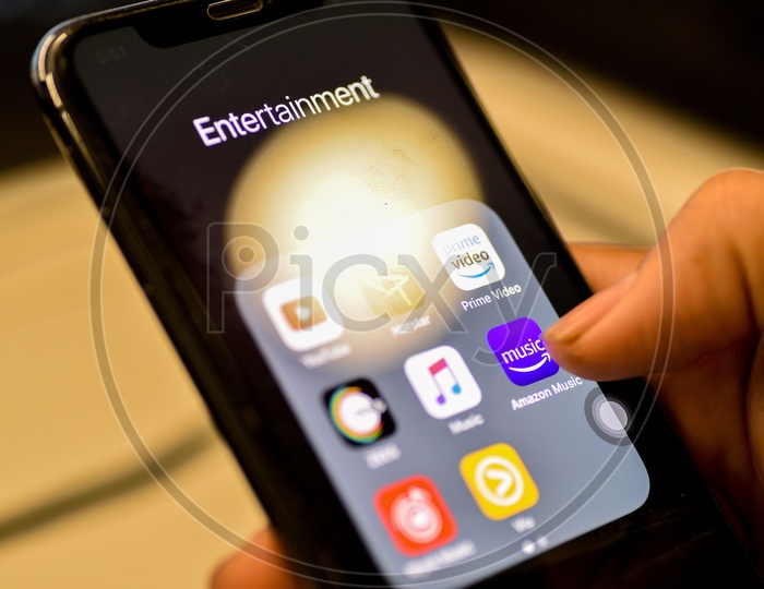 Entertainment Online Music Streaming Apps Installed Icons  On a Smartphone Screen Closeup With Man Finger Opening Amazon Music  App