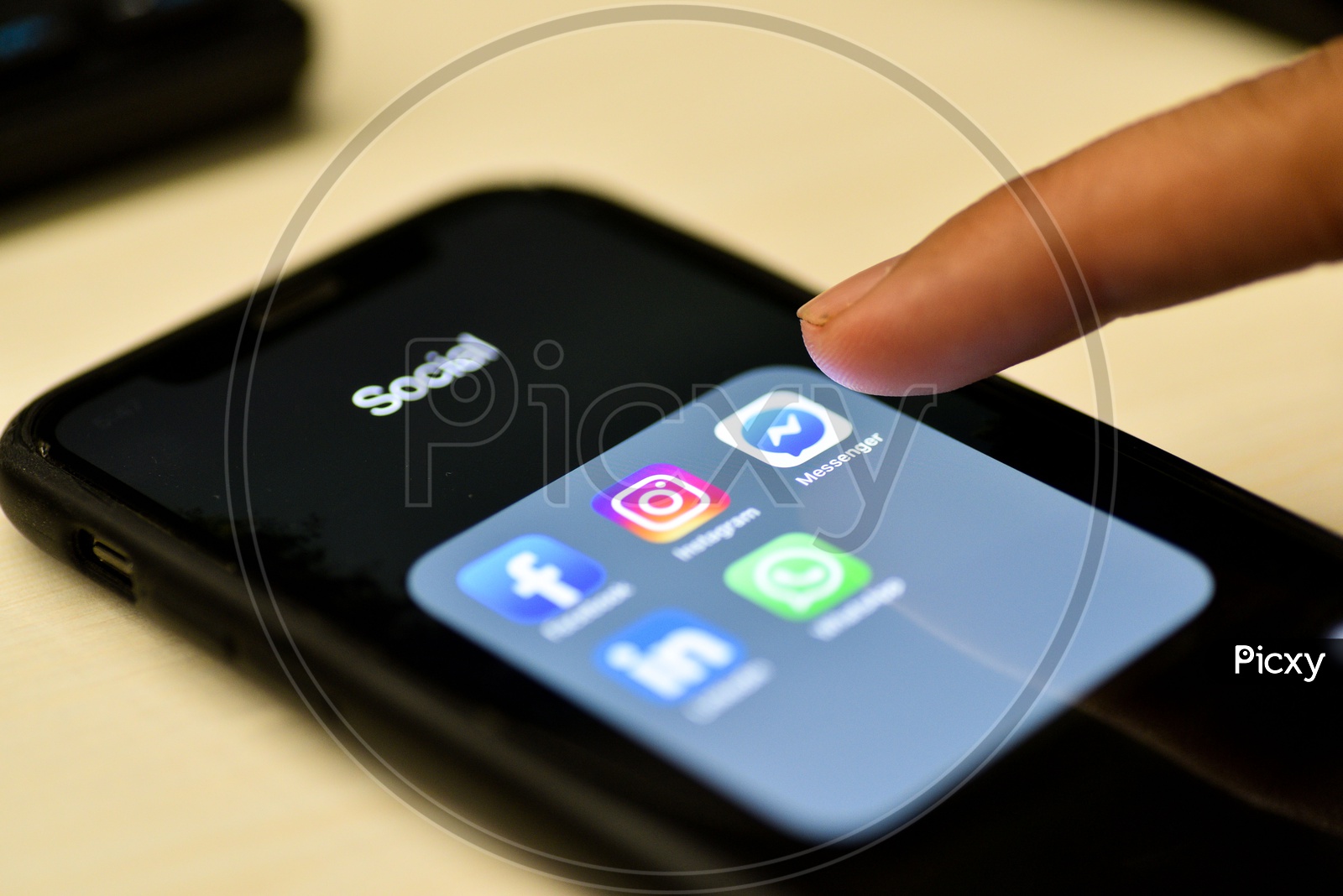 Social Network Apps On a Smartphone Screen Closeup With Man Finger On Facebook Messenger Icon