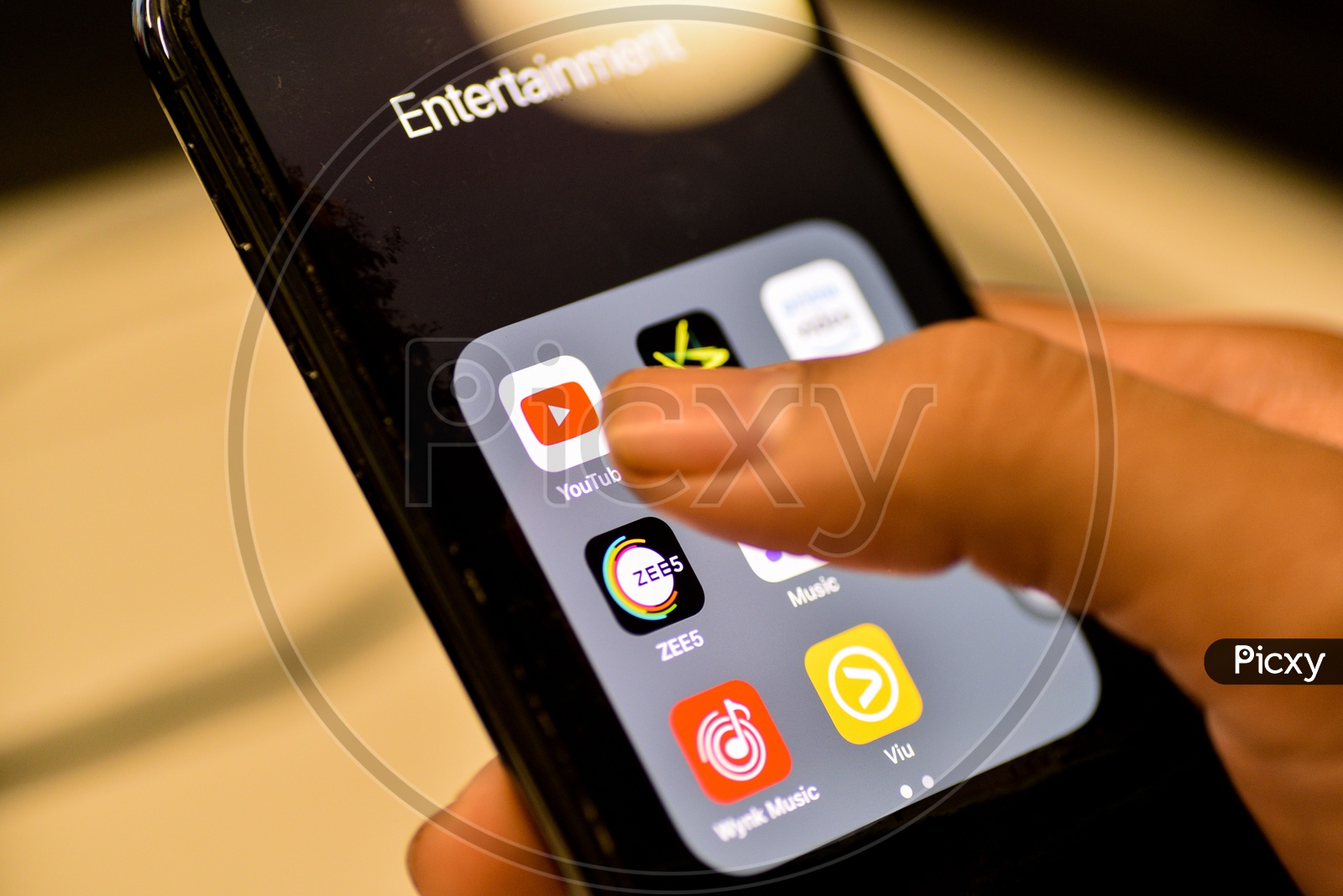 Entertainment Online Streaming Apps Installed Icons  On a Smartphone Screen Closeup With Man Finger Opening Youtube App