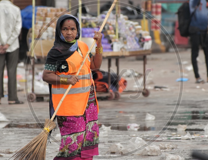 A GHMC Sanitary Worker Sweeping Roads At Charminar