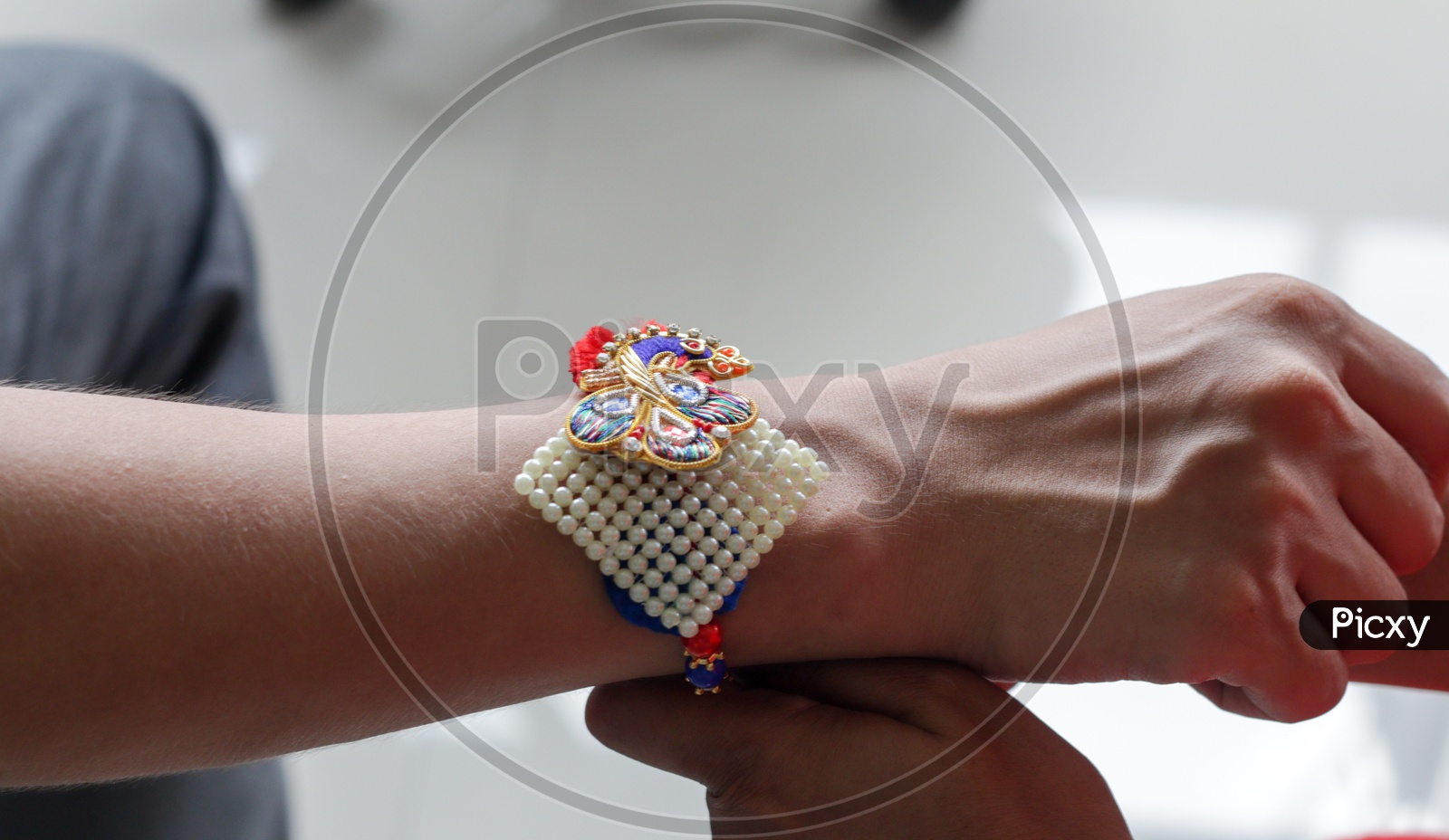 Hand Of A Lady Tying Rakhi In Hand Of A Guy During The Hindu Ritual Of Rakshabandhan With Selective Focus
