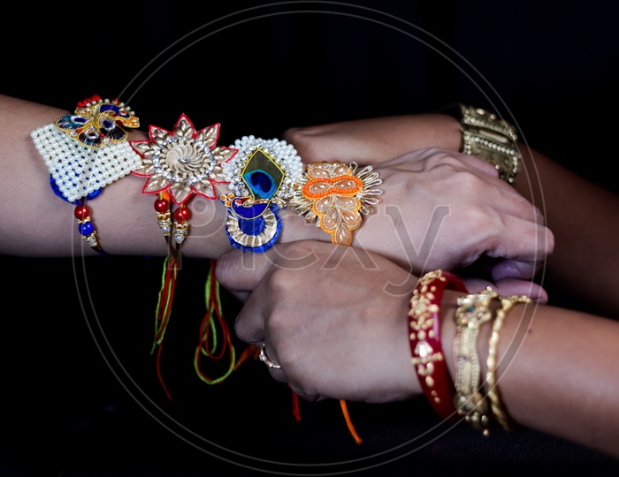 Sister Tying Rakhi To a brother Hand  During Traditional  Hindu Festival Raksha Bandhan  Over a Dark Black Background