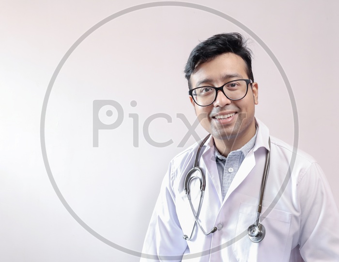 Male Indian Doctor In White Coat And Stethoscope With Space For Text In White Background