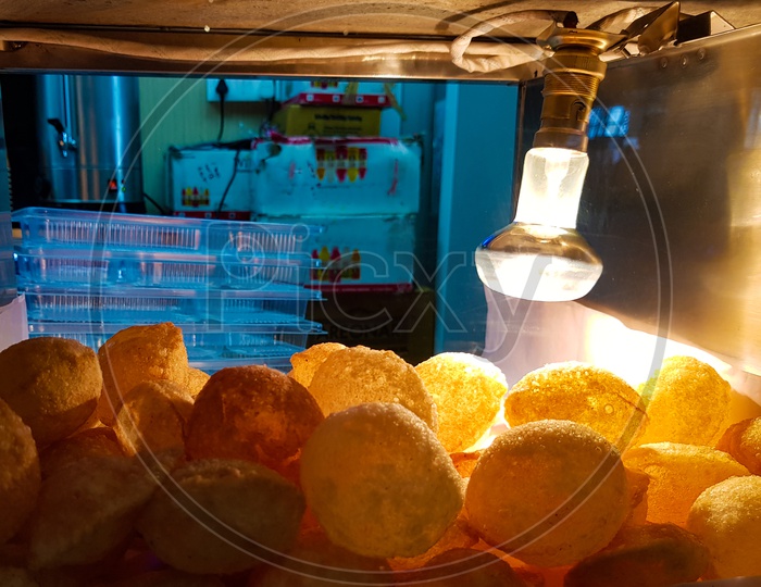 Golgappa chaat fuchka in glass box kept crisp by light bulb heat
