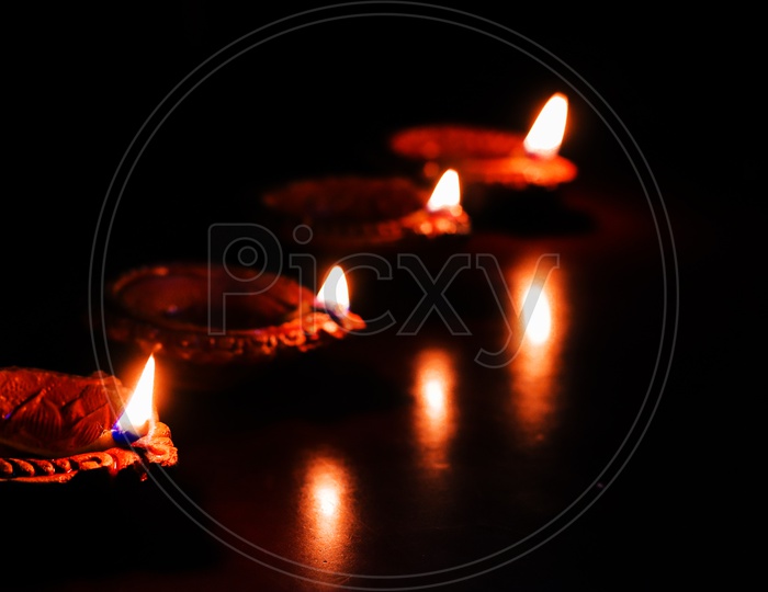 Diwali Diya or Lamps Lit During Diwali Celebrations Over Black Background  And Space For Text