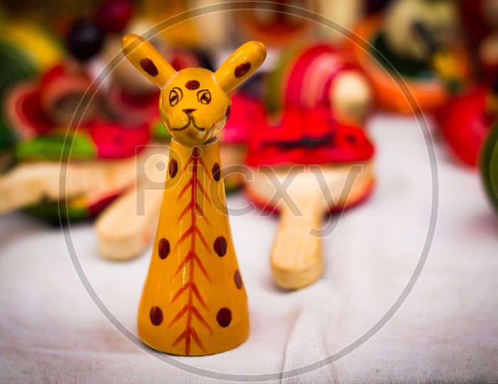 A Yellow Wooden Giraffe Figure Vintage Toy Against A Blurred Background