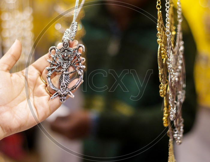 Hand Of A Lady Selecting Necklace Chain Metal Junk Jewellery At A Shop.