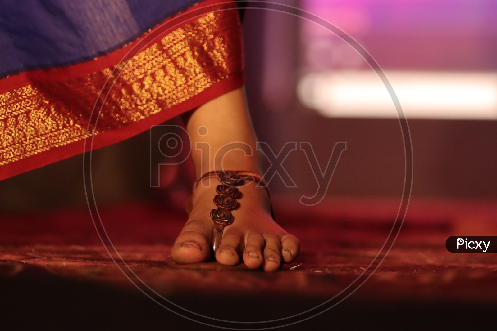 Feet Closeup Of a Woman Wearing Saree  Walking On Stage With  Sandal Footwear And Neon Lights