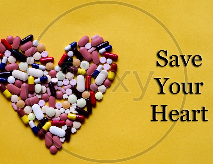 Medicine Pills Tablets Capsules In Shape Of Human Heart In Yellow Background With Space For Text
