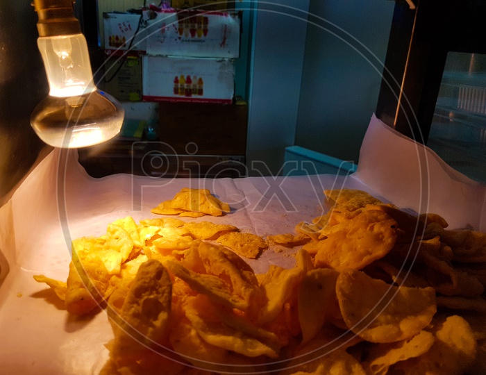 Paapdi chaat fuchka in glass box kept crisp by light bulb heat