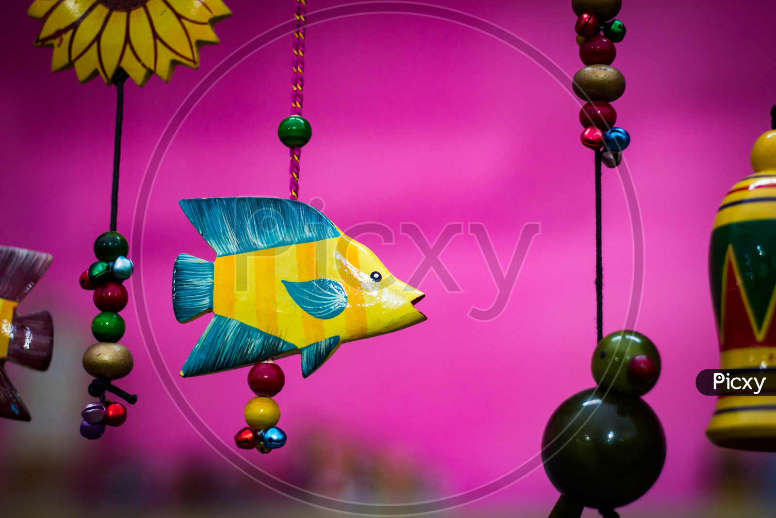 Yellow Wooden Fish With Blue Fins Suspended By Beaded String