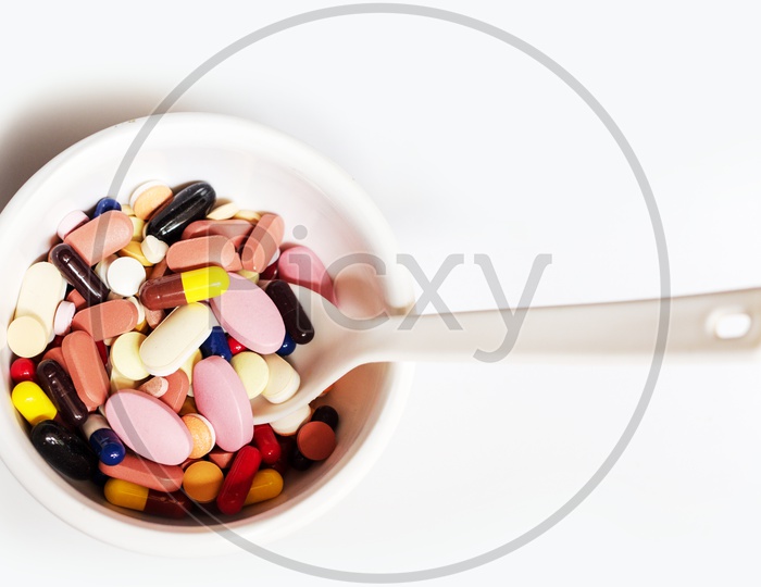 Bowl Of Medicine Pills Tablets Capsules In White Background