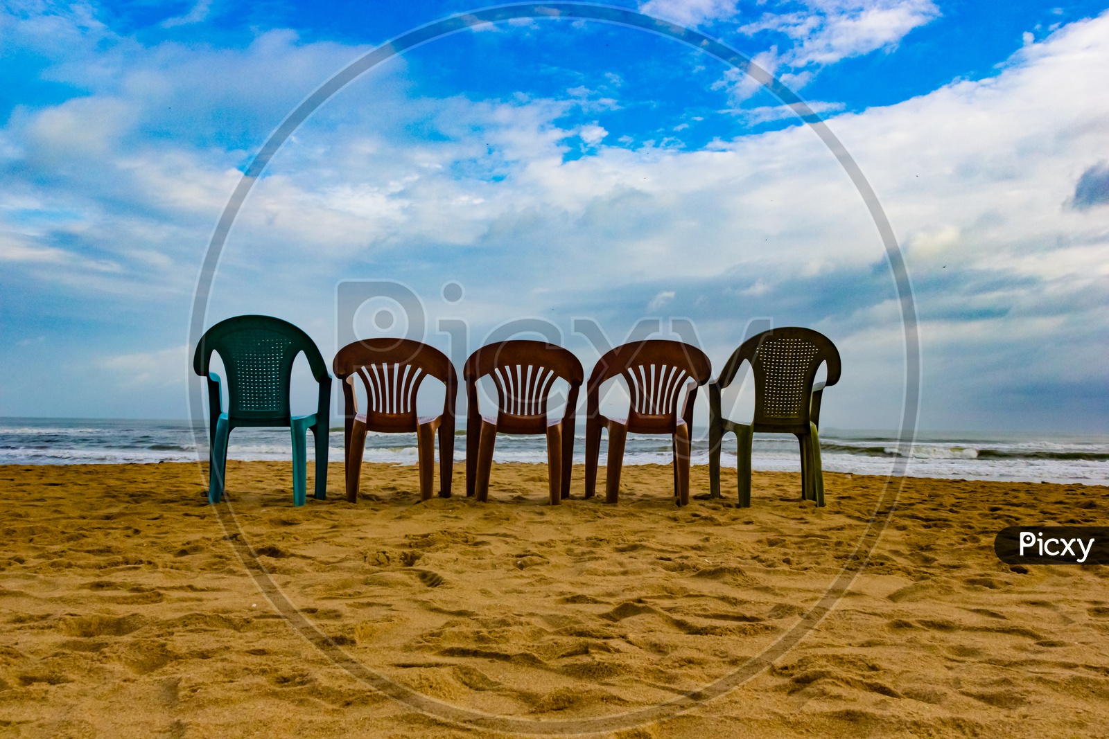 Five Multi Cloured Chair On A Sandy Beach With Blue Sky In A Sunny Day Perfect Holiday Destination