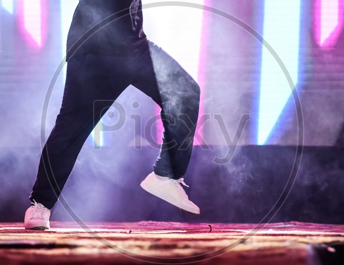 Feet Of A Dancer On Stage Doing Hip Hop Dancing Stance With Background Neon Lights