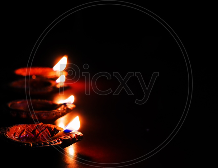 Diwali Dias  Lighted  Over a Black Background  And Space For Text