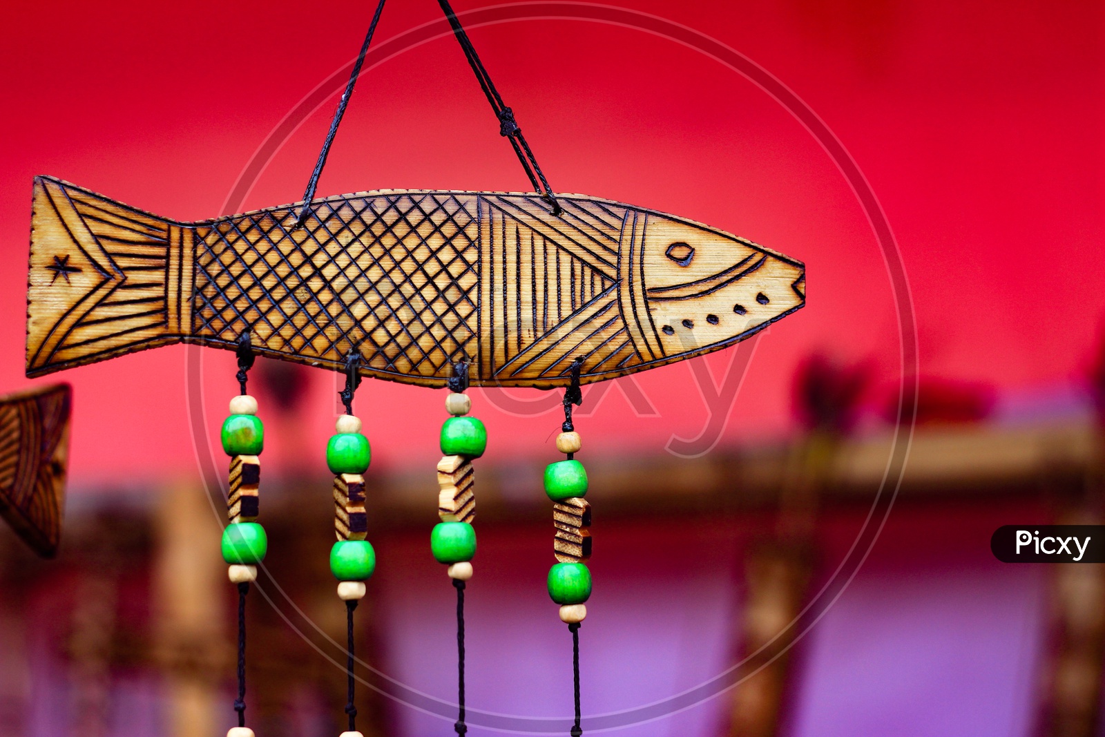 Hand Made Wooden Carving Engraved Fish Figure Artwork On Wood Plank With Suspended Green Beads On String.Tribal Artwork. Textured Background