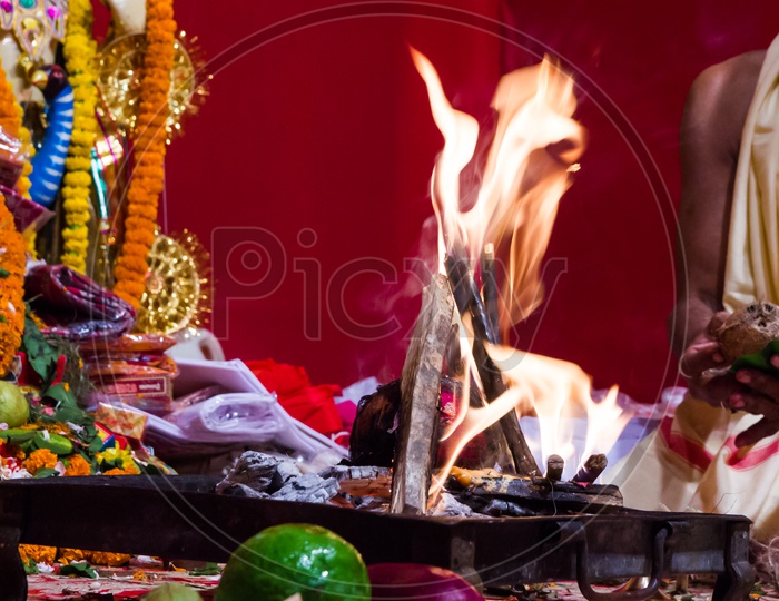 Hand Of A Priest Worshiping Hindu God With Fire And Yagna Ritual By Adding Fuel Ghee In Flame