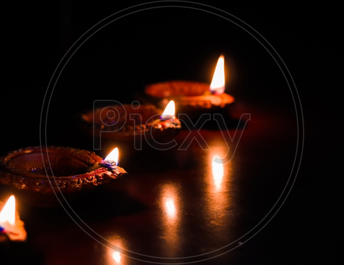 Diwali Diya or Lamps Lit During Diwali Celebrations Over Black Background  And Space For Text
