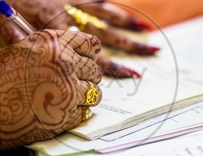 A Newly Married Indian Bengali Wife With Golden Wedding Ring Signing Marriage Registration Form