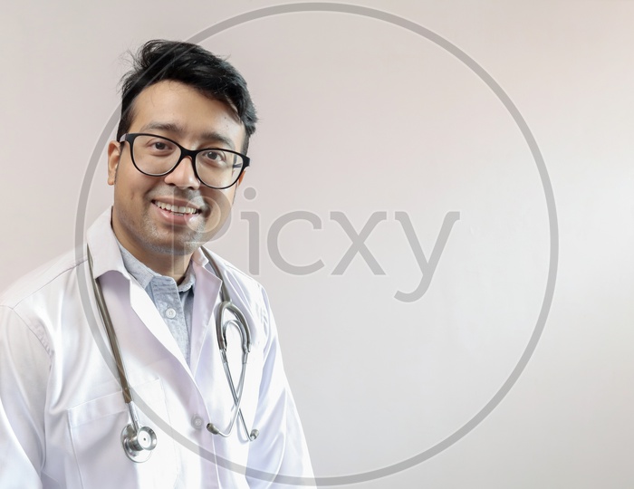 Male Indian Doctor In White Coat And Stethoscope With Space For Text In White Background