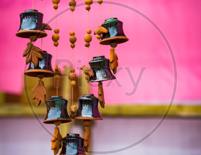 Earthen Wind Chime In Pink Background. Natural Musical Instrument