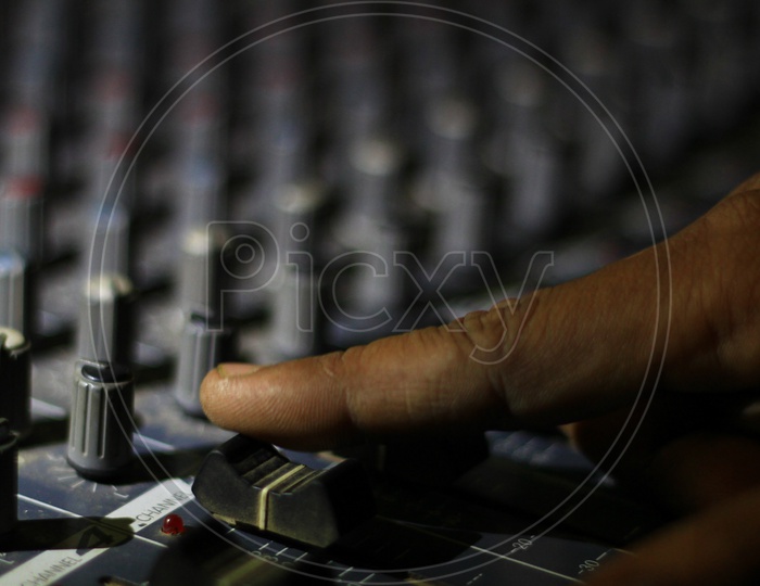Hands Operating Slider Of Light And Sound Board Console At A Concert Theater
