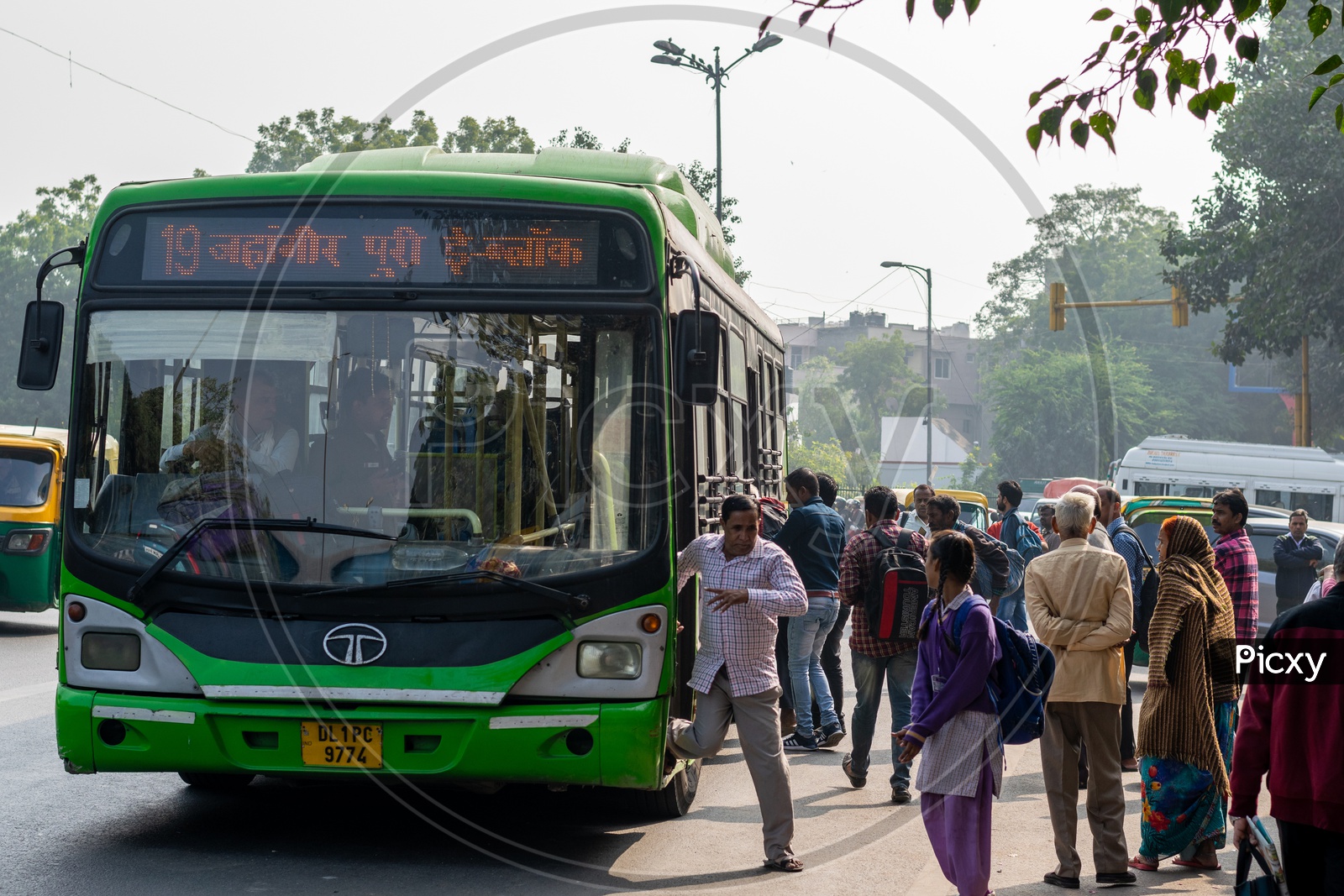 People getting on the bus and getting down from the DTC, Delhi Transport Corporation bus