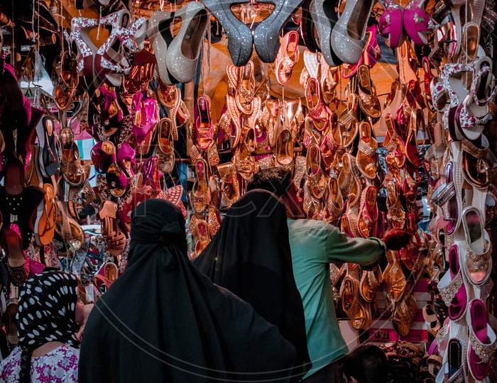 Muslim Woman Buying Footwear From a Local Vendor Stall