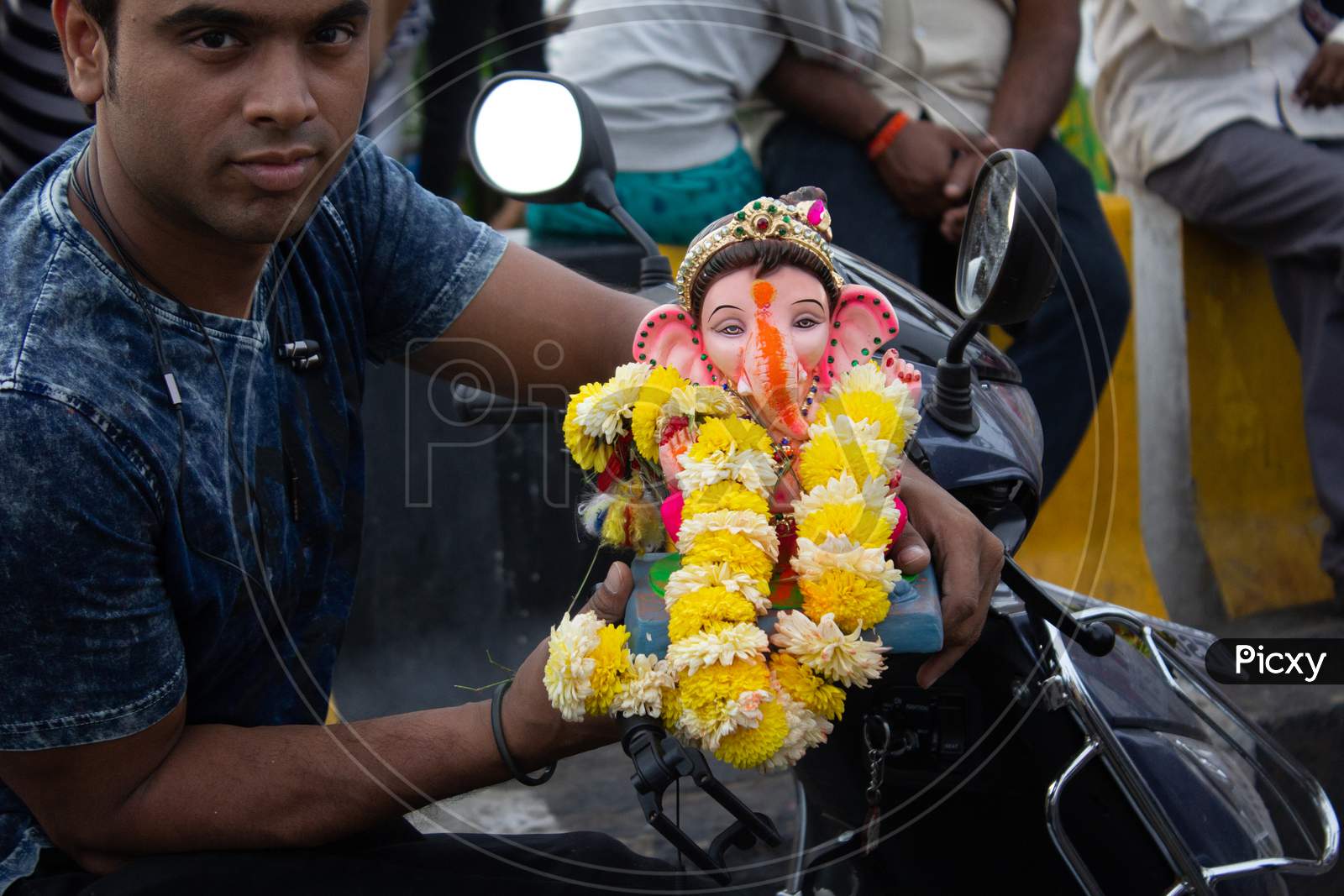 A Man Holding Ganesha Idol in Hand