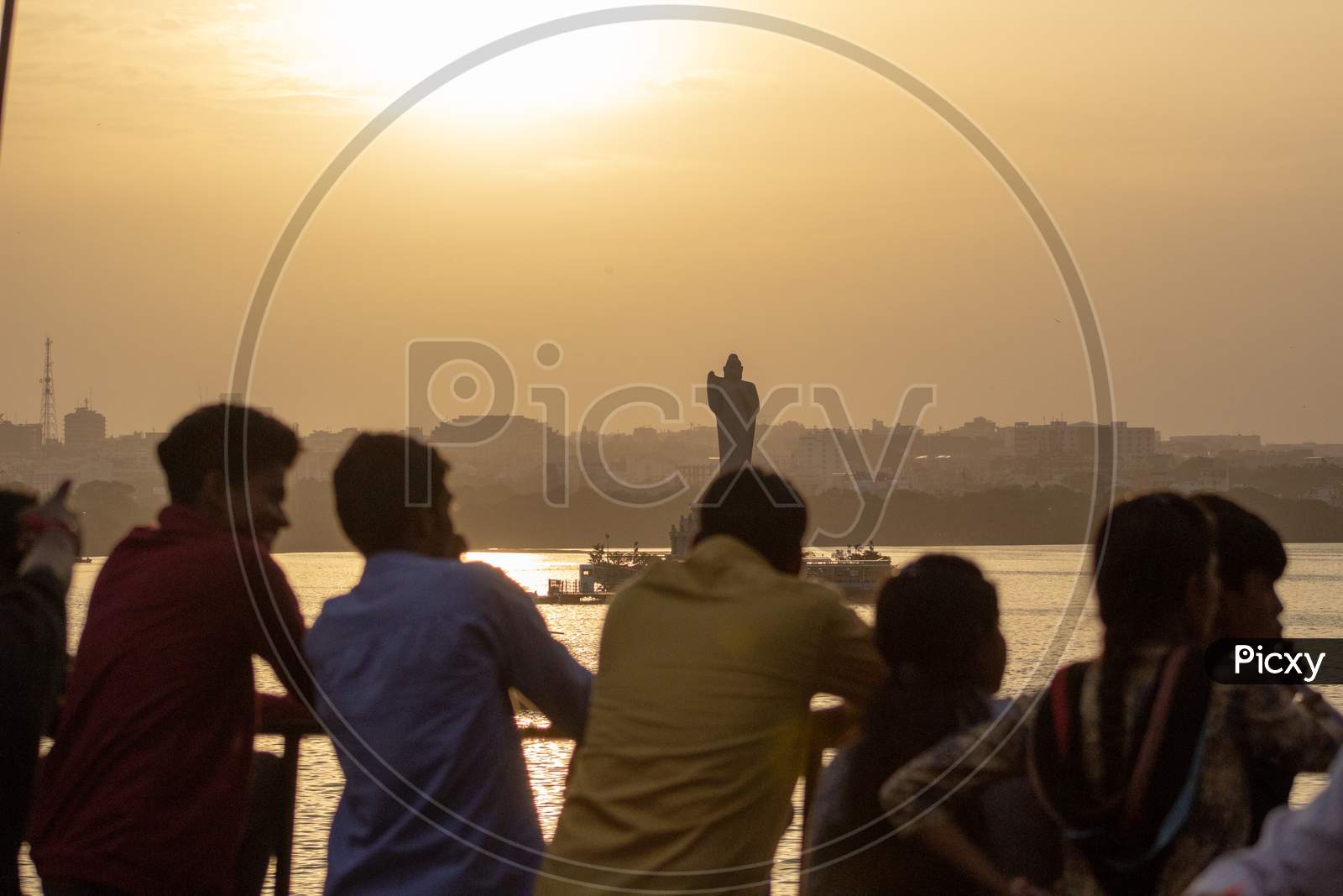 Silhouette of People with Buddha Statue in Background
