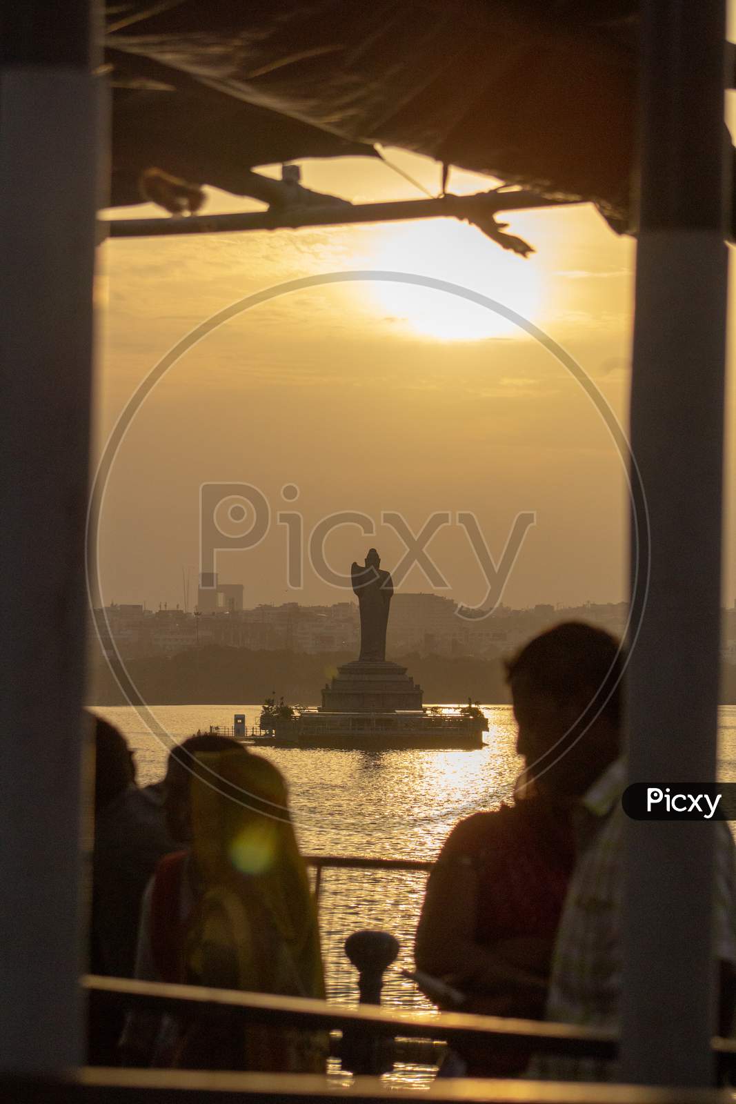 Silhouette of People with Buddha Statue in Background