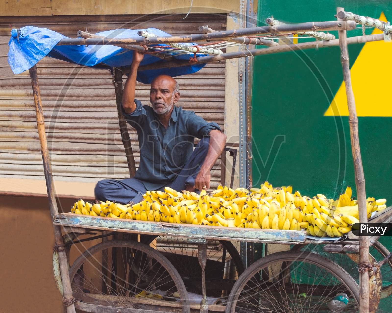 A Banana Vendor Sitting At a Stall