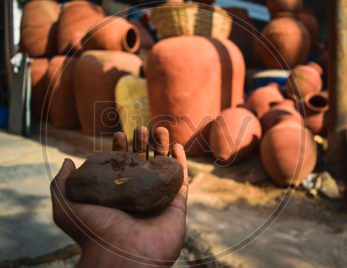 An Indian Potter Mixing Clay For Pots Making