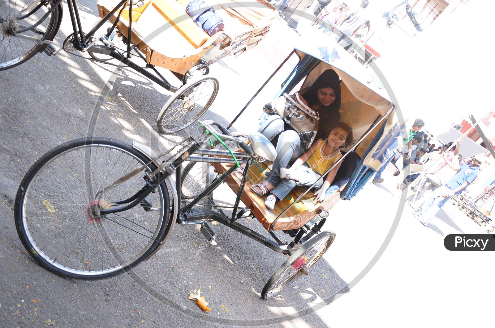 Indian Mother And Daughter Sitting In a Rickshaw in a market