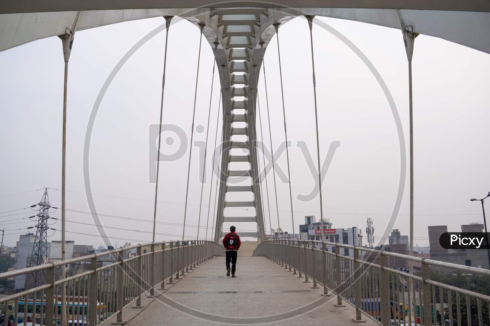 A man walking at a foot over bridge over Outer ring road Delhi