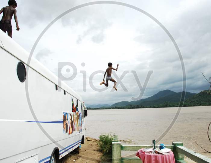 Children Diving To River From a Bus