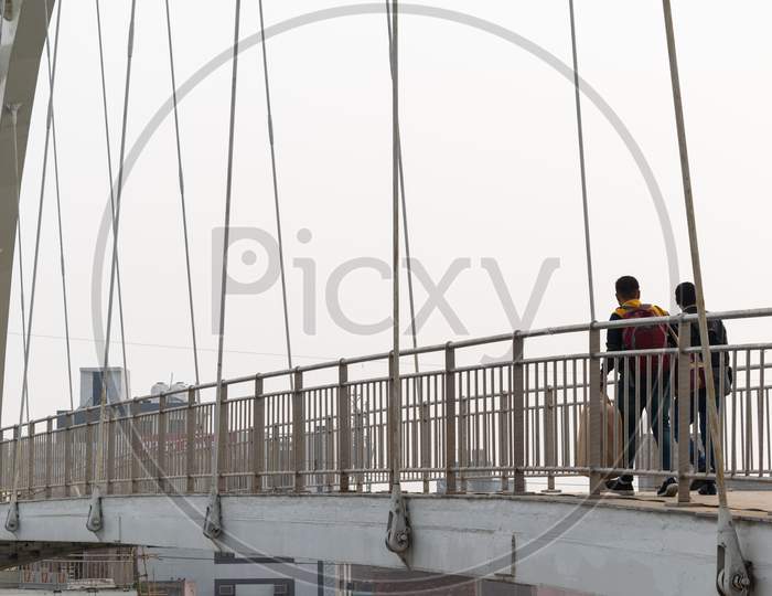 Two men walking at a foot over bridge over Outer ring road Delhi