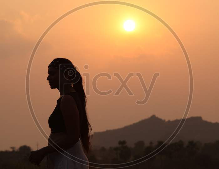 Silhouette of Woman Doing Workouts With Sunrise Sun in Background