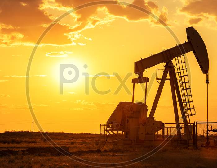 Oil Pump Oil Rig Energy Industrial Machine For Petroleum In The Sunset Background