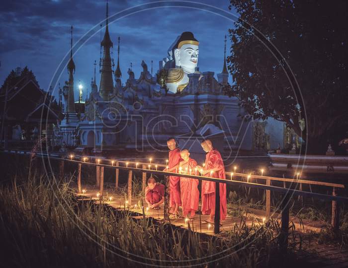 Young Novice Monks Lighting Up Candlelight At Temple, Low Light Setting, Shan State, Myanmar.